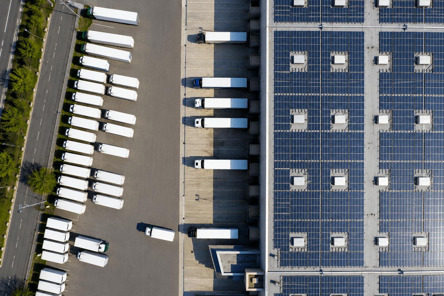Vue aérienne d'un bâtiment métallique à bardage anthracite avec lanterneaux en toiture en zone industrielle, Steel Shed for Business